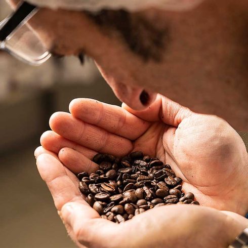 Person riecht an Kaffeebohnen