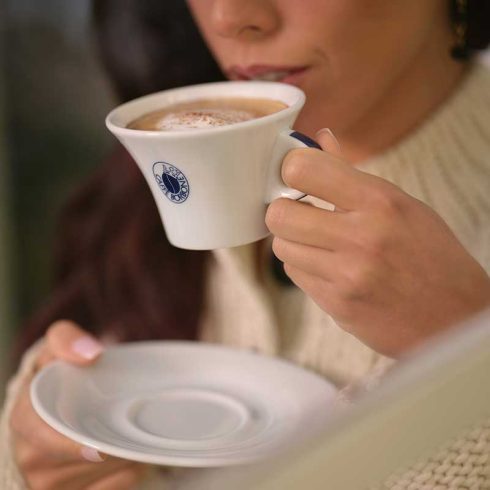 Person trinkt Cappuccino