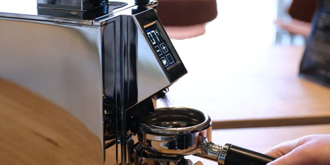Elektrische Kaffeemühle wird mit Siebträger bedient