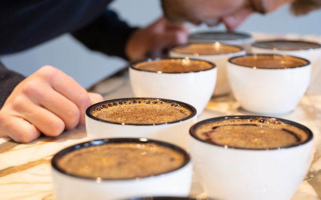 Person riecht an Kaffeebecher