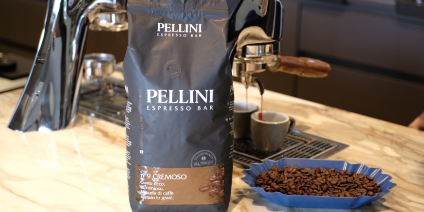 Schwarze Kaffeeverpackung vor einer Siebträgermaschine