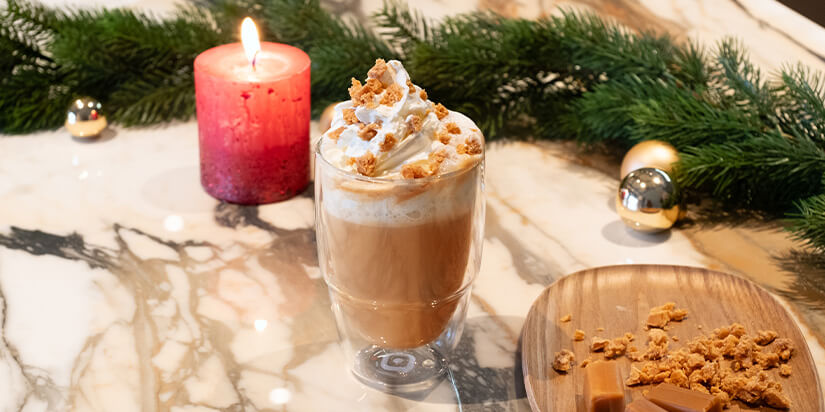 Toffee Nut Latte Rezept Kaffee-Latte im Glas mit Sahne und Karamellstückchen