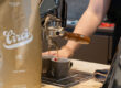 Kaffeeverpackung steht vor einer Siebträgermaschine