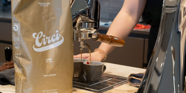 Circi Miscela Oro 100 % Arabica Produkttest Kaffeeverpackung steht vor einer Siebträgermaschine