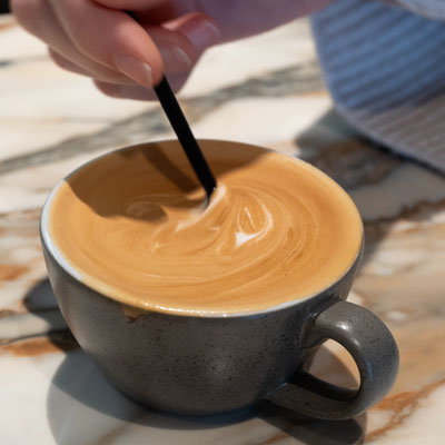 Cappuccino wird mit einem Löffel umgerührt
