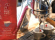 Espresso fließt aus Siebträger in zwei Tassen. Daneben steht die Verpackung Essse Selezione Speciale