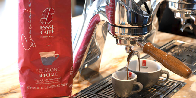 Espresso fließt aus Siebträger in zwei Tassen. Daneben steht die Verpackung Essse Selezione Speciale