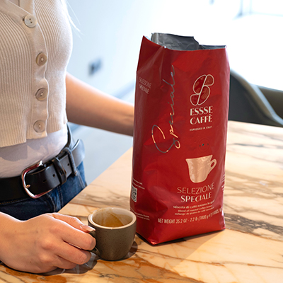 Essse Selezione Speciale im Produkttest Rote Verpackung des Essse Selezione Speciale. Frau hält Espressotasse daneben.
